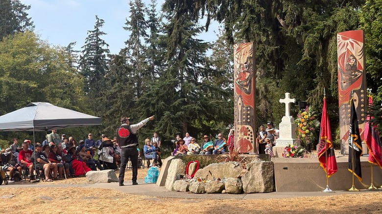 A Suquamish Tribe member speaks to a group of people gathered around the grave of Chief Seattle in Squamish, Washington
