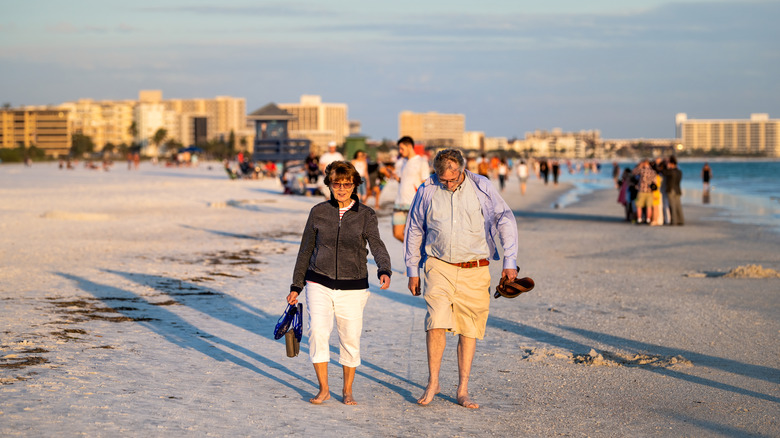 Couples walk on one of Sarasota's beaches.