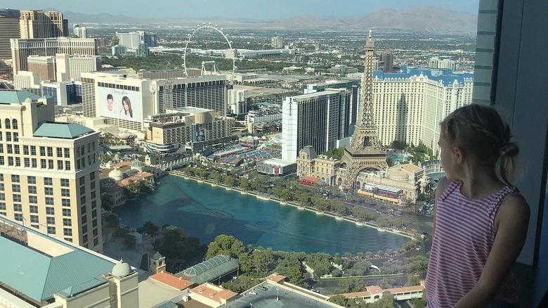 Girl in hotel room looking out at the Strip view from the Vdara