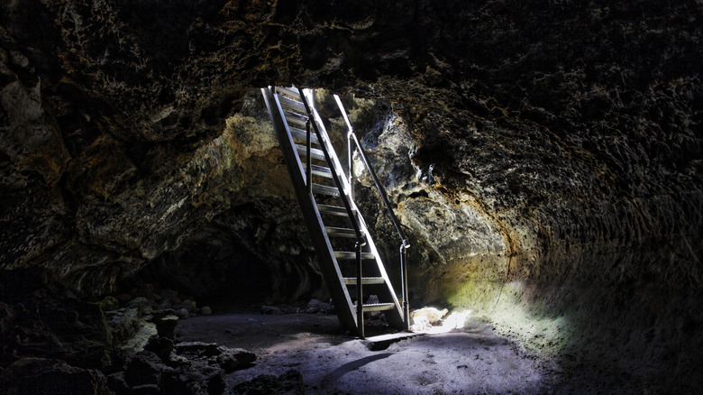 A ladder into a dark lava tube in Lava Beds National Monument, California