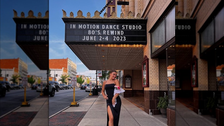 Woman posing with flowers in front of the  Ritz Theatre in Downtown Tiffin, Ohio