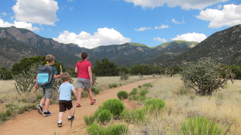 A mother and her kids hike along a path in New Mexico