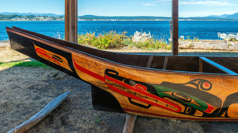 Traditional wooden canoe painted in red, green and black by the We Wai Kai first nation native people in the village of Cape Mudge on Quadra Island, Canada