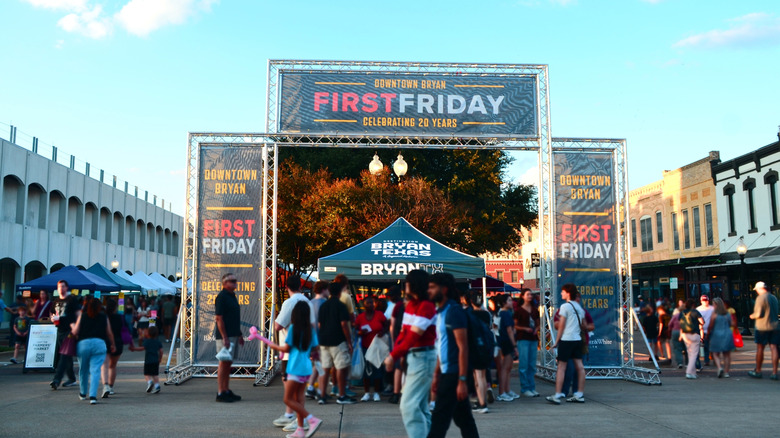 First Fridays in Downtown Bryan with the entrance archway in the middle and promotional tents for business in the background