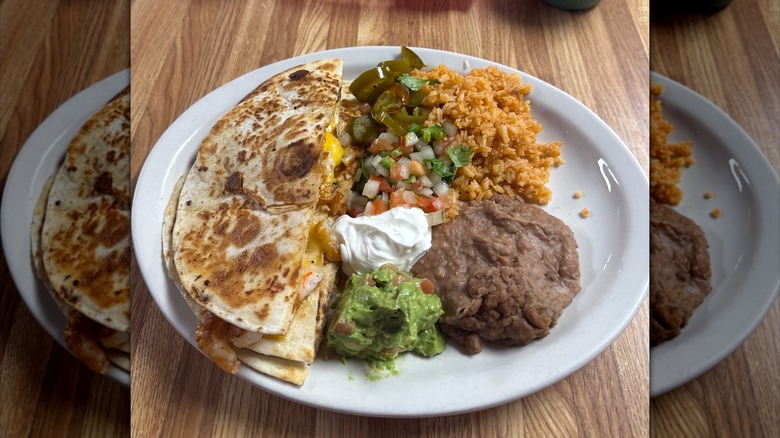 Quesadilla plate with red rice, refried beans, guacamole, sour cream, and pico de gallo rom El Alamo Cafe, Hearne, Texas