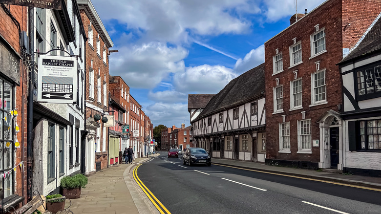A street and road lined with brick buildings in Tewkesbury, England.