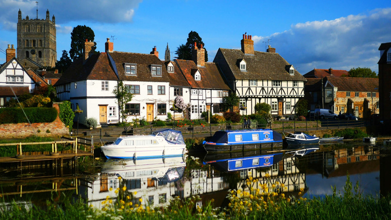 Boats on Mill Bank with houses in the background in Tewkesbury, England.