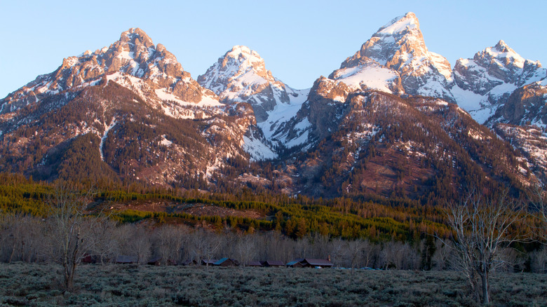 Mountains of the Grand Tetons lit by the sun with snowy caps.