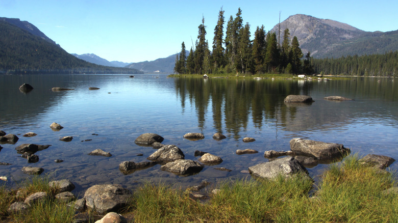 The placid Lake Wenatchee on a sunny day with surrounding mountains and trees.