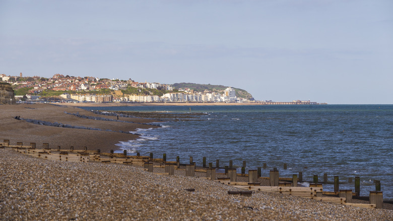 An empty, pebbly beach with white buildings on the horizon in Bexhill-on-Sea, England