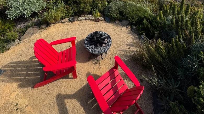 Two red chairs in front of a fire place at Treebones Resort