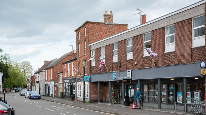 Brick buildings lining market street Bingham England on cloudy day.