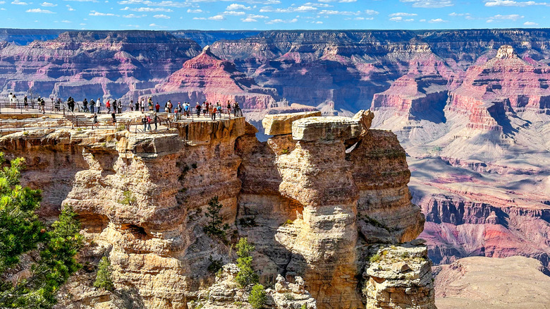 People standing on top of cliffs at the Grand Canyon