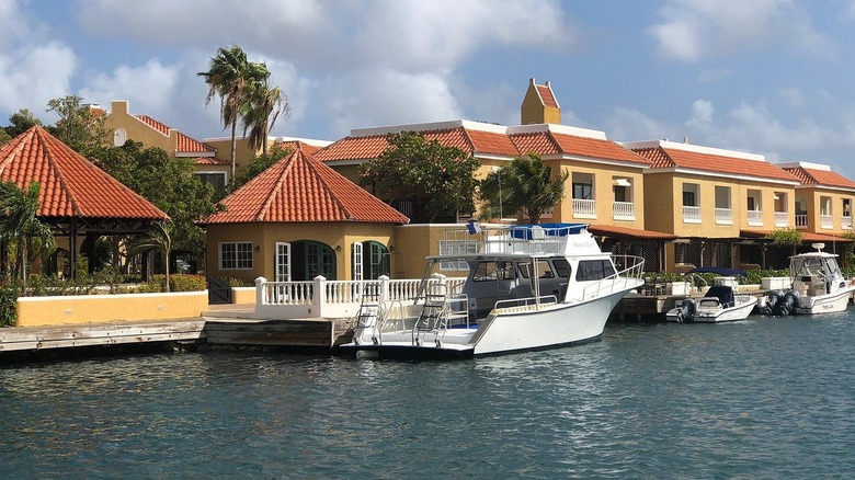 Boat moored by waterside villas