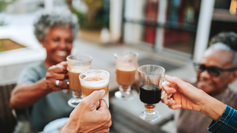 People toasting with mugs of coffee
