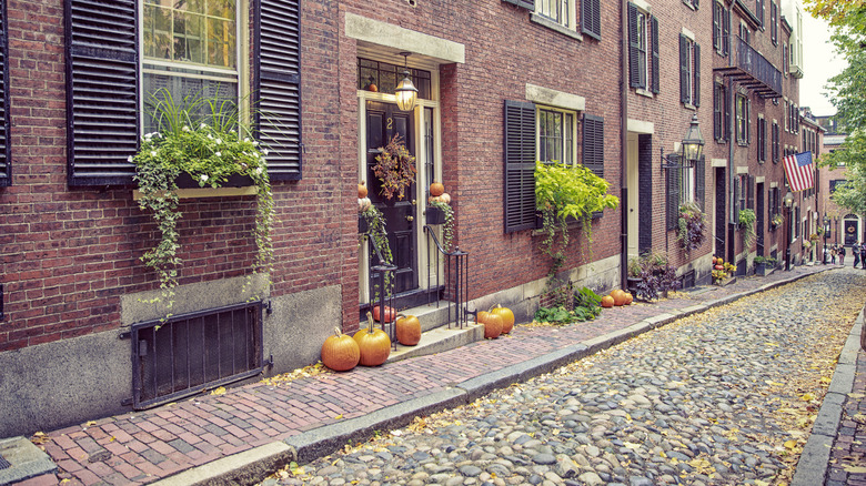 Pumpkins placed on stoops in front of brick homes on Acorn Street in Boston's Beacon Hill neighborhood
