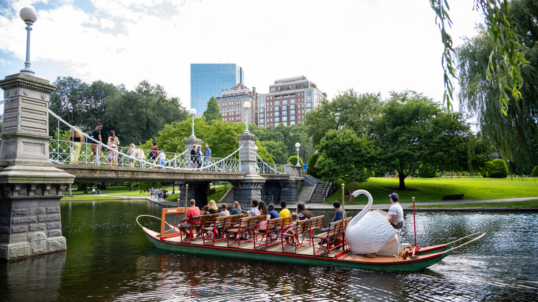 boat on water in a park going under bridge
