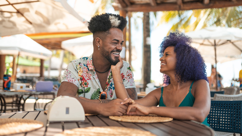 A couple laughing and relaxing at an outdoor Brazilian restaurant