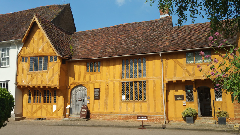 A mustard-coloured Tudor museum with beams in Lavenham village