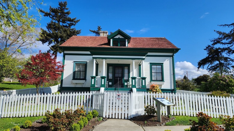 A historic lighthouse keeper's cottage surrounded by trees at Browns Point Lighthouse Park.