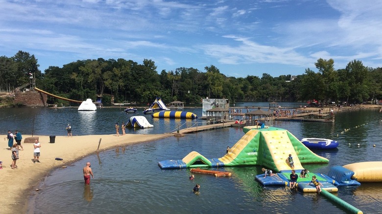 Brownstone Adventure Sports Park in Portland, Connecticut, with inflatable water obstacles, ziplines, and a beach area