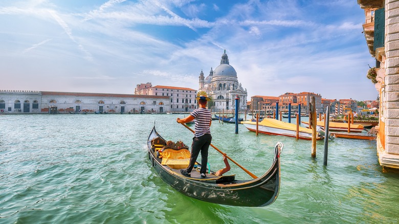 man maneuvering a gondola in Venice, Italy