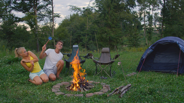Two campers swat at mosquitoes