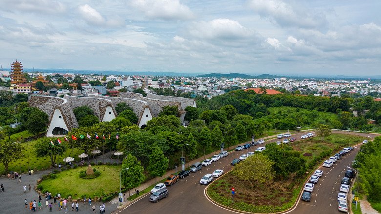 Aerial shot of Buon Ma Thuot overlooking the green landscape with the Coffee Museum in the foreground