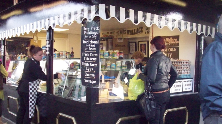 The Bury Black Pudding Company stall with a patron waiting for their order