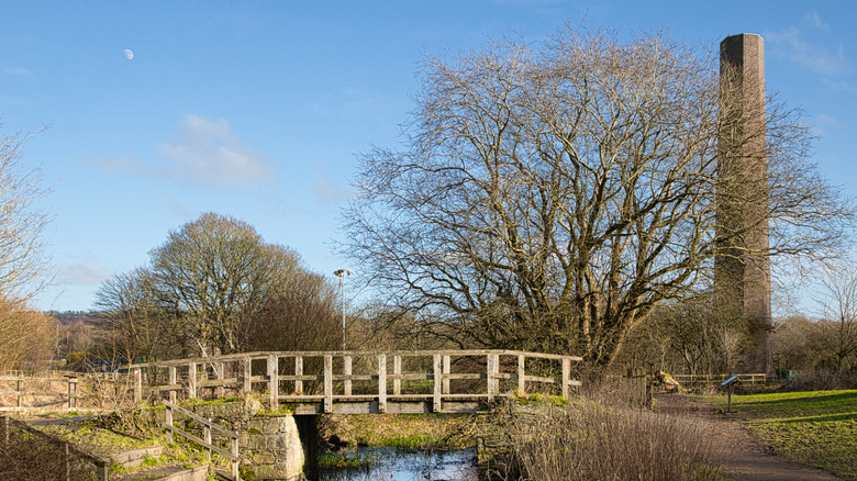 Wooden bridge crossing a small waterway at Burrs Country Park, Bury, UK