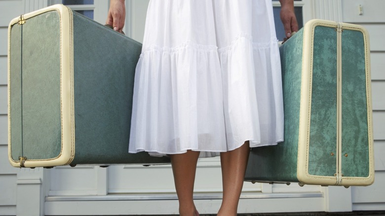 Woman holding vintage luggage