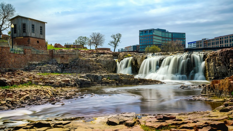 Water fall spilling into a river with buildings behind in Sioux Falls, South Dakota