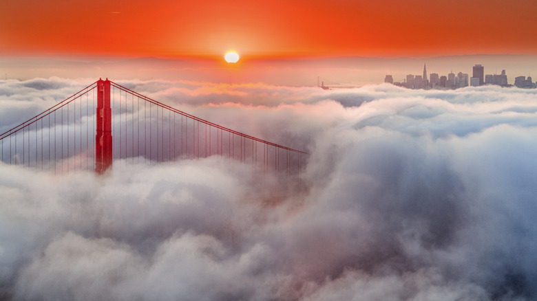 Aerial view of clouds swarming Golden Gate Bridge before San Francisco skylight