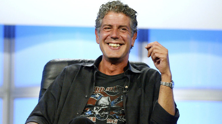 A smiling Anthony Bourdain answering questions at a public event