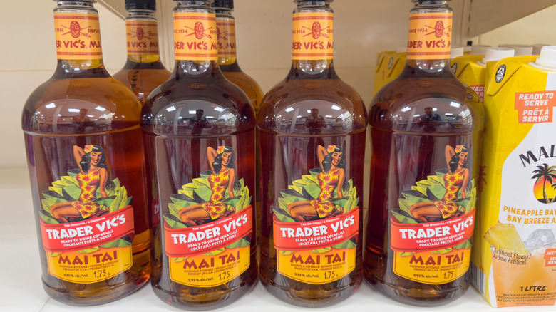 A row of bottles of Trader Vic's Mai Tai mix on a shelf