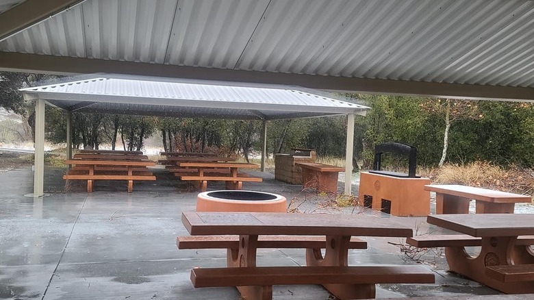 Covered picnic tables and a firepit at one of the large group campsites at Silverwood Lake
