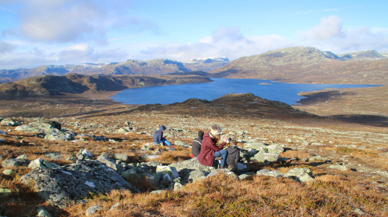 Hikers sitting on a rocky hillside overlooking Silverwood Lake