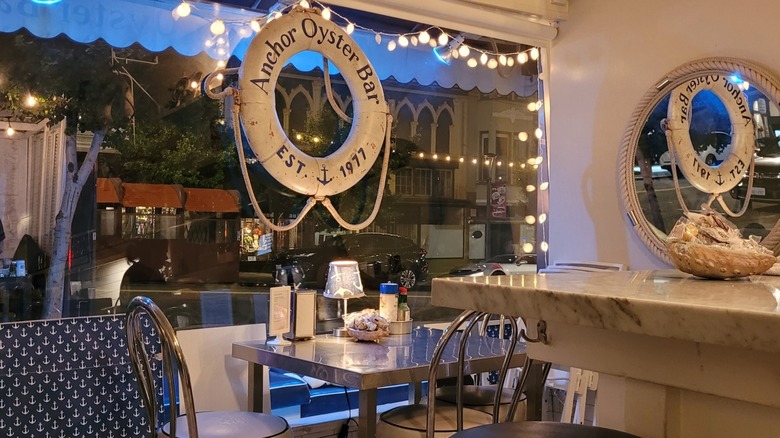 A table in front of the window and beneath string lights at Anchor Oyster Bar in San Francisco.