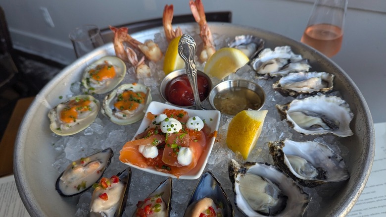 The crudo sampler on ice at Bar Crudo with raw clams, oysters, muscles, shrimp, and salmon.