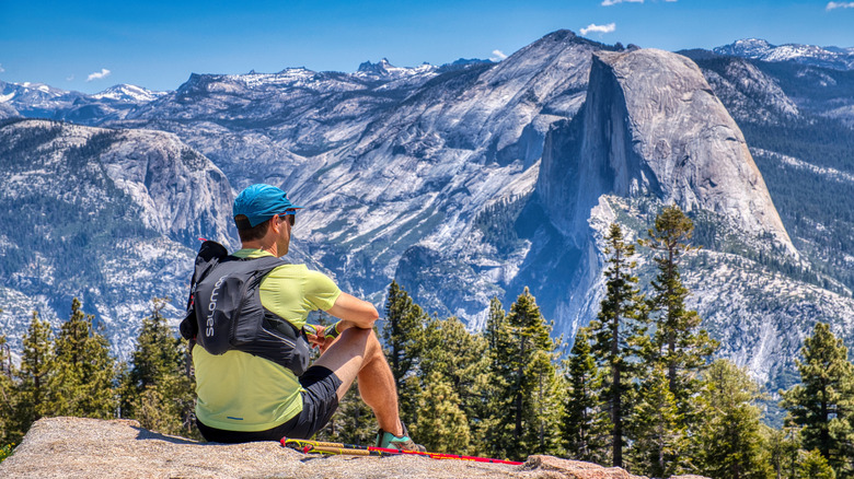 A hiker looks across the Yosemite Valley at the Half Dome