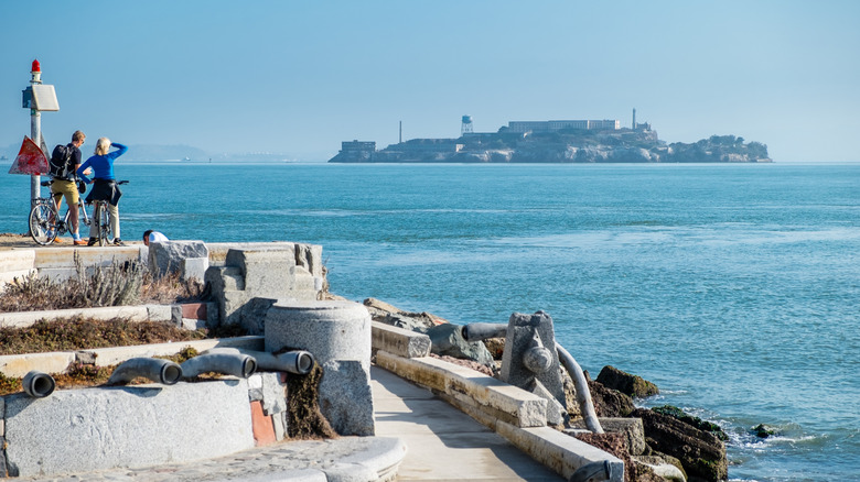 Tourists looking at Alcatraz Island from the Wave Organ acoustic sculpture in San Francisco