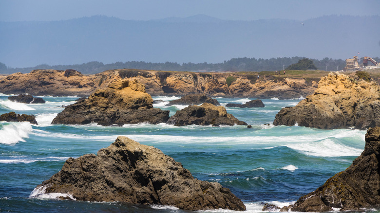 View of waves and rock formations in the water from Glass Beach in MacKerricher State Park during the day.