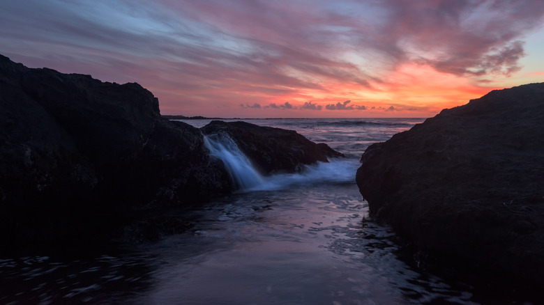 Sunrise over the ocean from MacKerricher State Park with water splashing up on rocks in the water.
