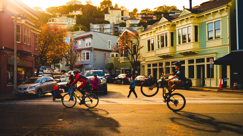 Two cyclists riding down the street in Sausalito at sunset