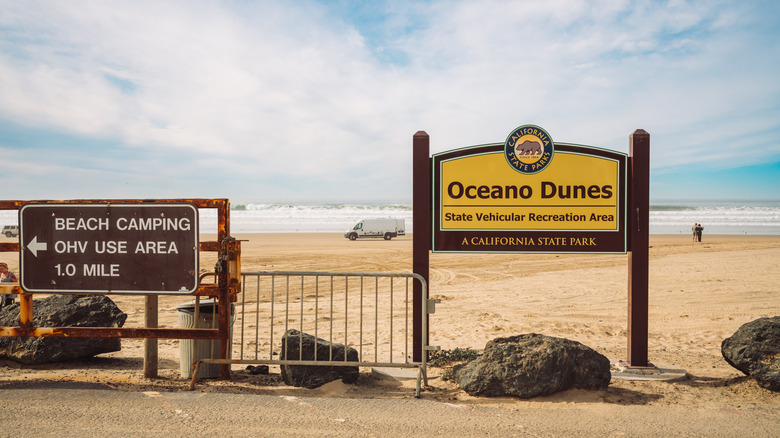 Signs for Oceano Dunes and beach camping on the sandy shore