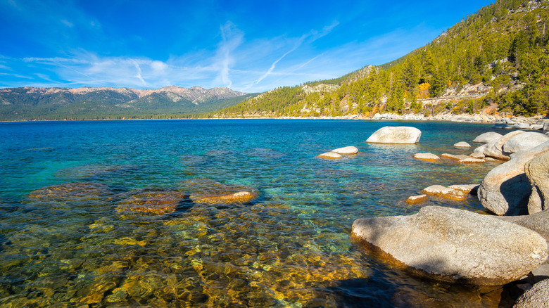 Large boulders along the shore of South Lake Tahoe with the mountains in the distance