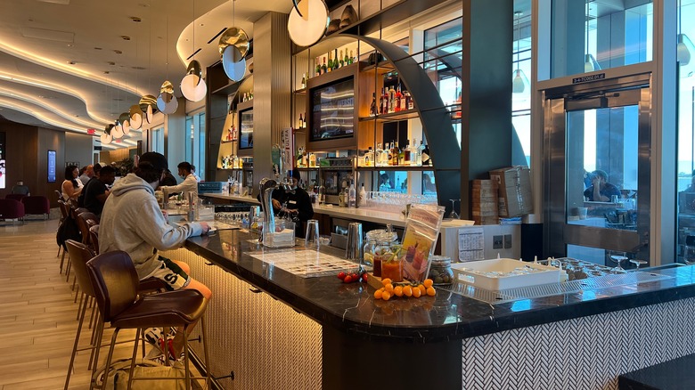 People seated at a bar inside an LAX lounge
