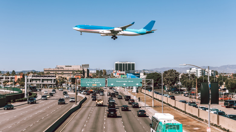 Plane flying over highway leading to LAX