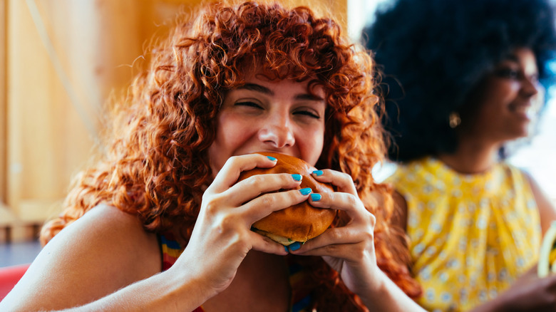 Woman biting into a hamburger