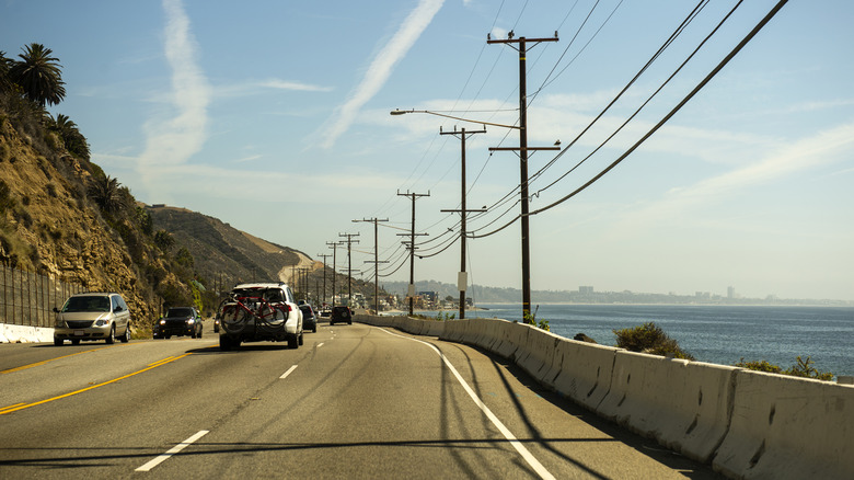 Cars driving on the Pacific Coast Highway with ocean views between Malibu and Santa Monica, in California.